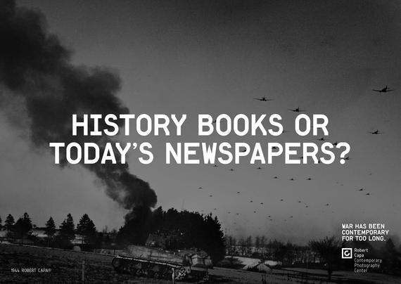 A black and white photo with centered text that reads "HISTORY BOOKS OR TODAY'S NEWSPAPERS? ". The photo shows a destroyed tank with a dark smoke trail and planes flying in formation across the sky.
