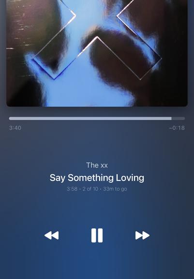 Screenshot of Marvis music playing app on iOS. Shows album cover of The xx’s “I See You” and a progress bar at the top. In the middle, centered text:

The xx
Say Something Loving
3:58 • 2 of 10 • 33m to go

At the bottom there are control buttons to rewind, pause and fast forward.