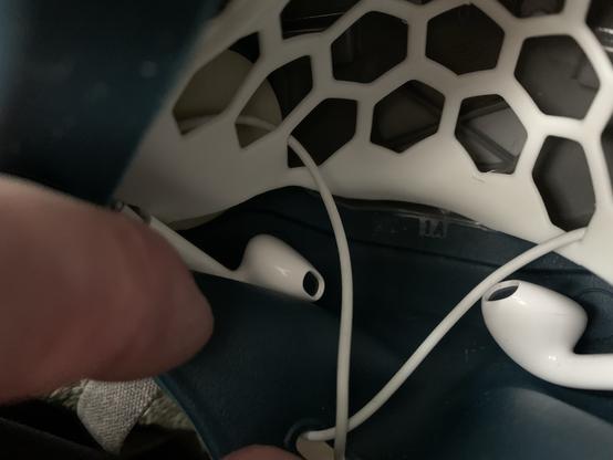 Tiny earbud headphones acting as microphones inside an elastomeric mask for use with an external amplifier/speaker. The wires are threaded through a silicone lipstick protector which keeps them away from the skin and retains them in place just below each side of the mouth.