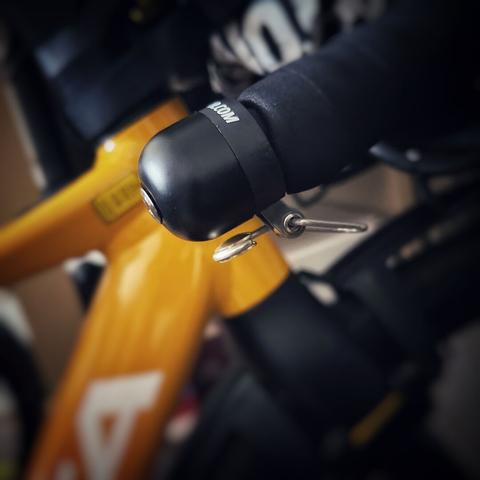 Nahaufnahme eines Fahrradgriffs mit einer Klingel und einem Teil des Rahmens, mit unscharfem Hintergrund.

Close-up of a bicycle handle with a bell and part of the frame, with a blurred background.