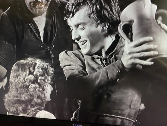 Edmond O’Brien in The Hunchback of Notre Dame holding up a pitcher and looking down at Maureen O’Hara