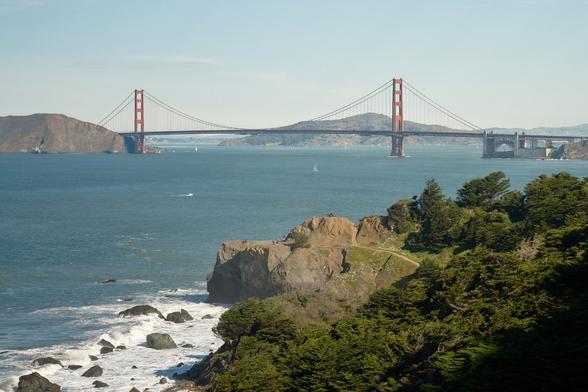 The photo shows a view of the Golden Gate Bridge from the coast. The bridge is the most famous suspension bridge in the world, and it spans the San Francisco Bay. The bridge's towers are painted international orange, a color chosen to make the bridge more visible in the fog that often rolls in from the Pacific Ocean.
(From Gemini)