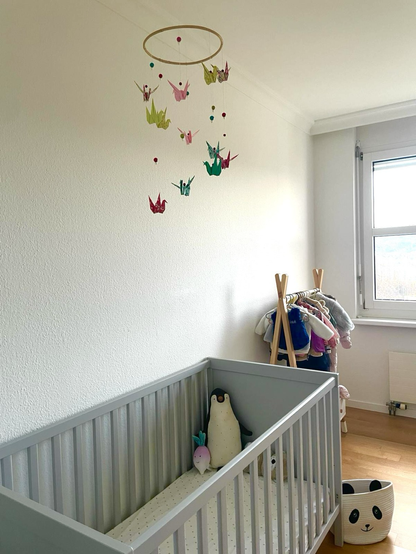 Mobile décoratif en origami dans chambre d’enfant
