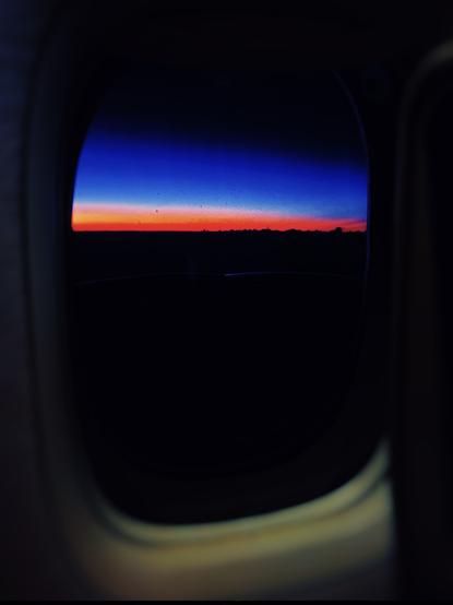 Window view from a plane to the Seychelles and you see a beautiful Aurora - a rosy dawn outside.