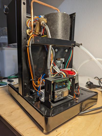 View to the backside of the Rancilio Silvia espresso machine without the casing. 

The open electronic box is visible in the foreground with the CleverCoffee PCB mounted inside.