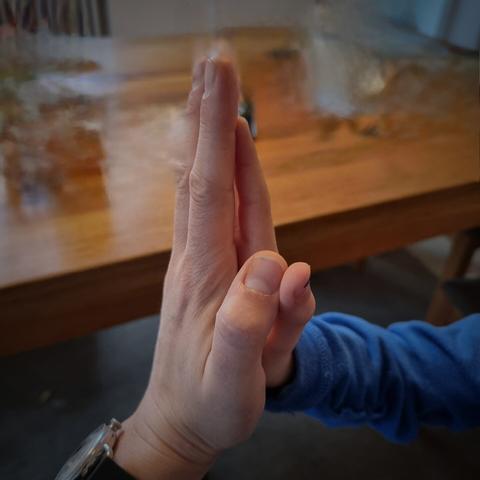 Ein High Five einer großen und einer kleinen Hand