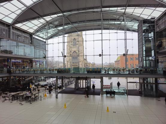 An internal photo of the Millennium Foyer showing lots of windows, a wide, closed space, and a curved windowed roof.