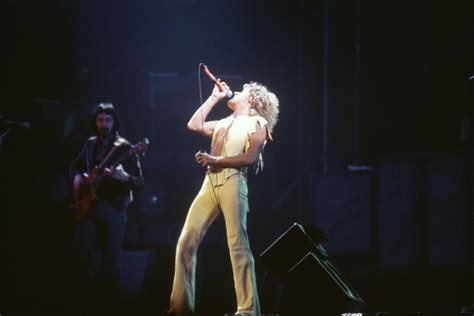 Roger Daltrey holding a mic, long hair, singing with his head held back