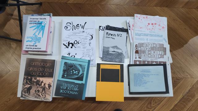 Une petite table sur laquelle sont disposés une série de publications. Ce sont des readers et des zines, de différentes factures et différentes esthétiques.