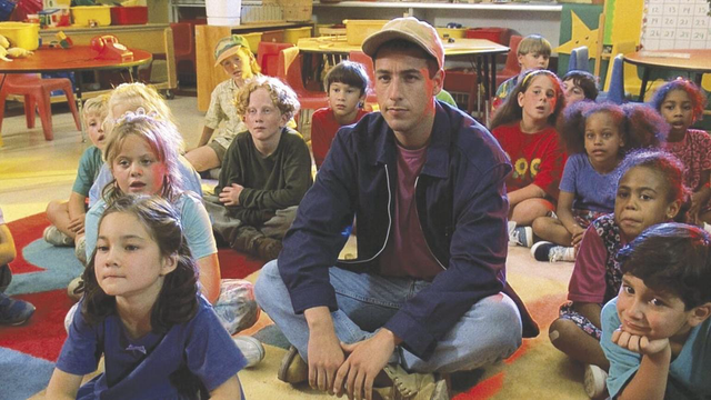Adam Sandler sitting on the floor with kids in a classroom in Billy Madison