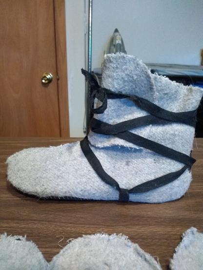 Practice slippers from wool blanket with black crossgarter boot lacing. A midcalf boot top that wraps around the leg.