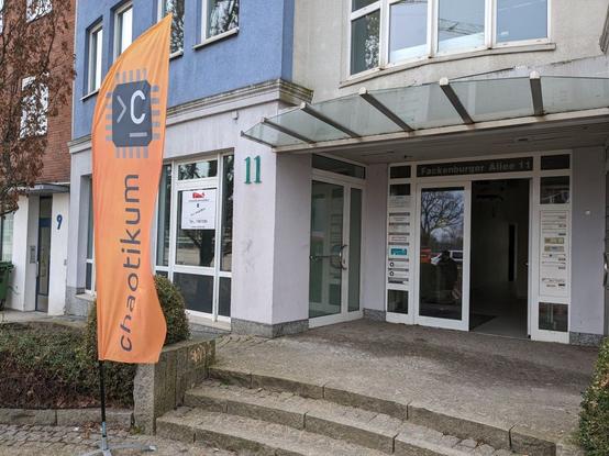 Eingang eines Gebäudes. Eine orange Flagge mit der Aufschrift Chaotikum