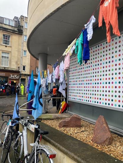 Curved building, with line of washing and bicycles parked next to street sign