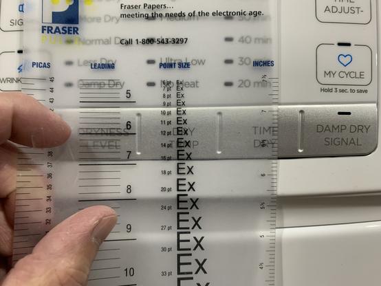 Me holding a transparent E-scale typesetting ruler over selector button to determine the type size is 12 pts.

It slipped slightly when phtographing, sorry!