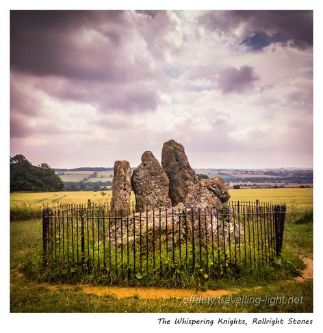 A tight group of one recumbent and four upright stones, surrounded by metal railings.