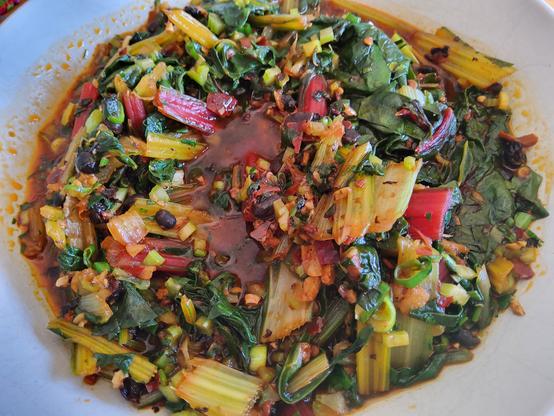 Cooked rainbow chard with fermented black beans in red sauce.