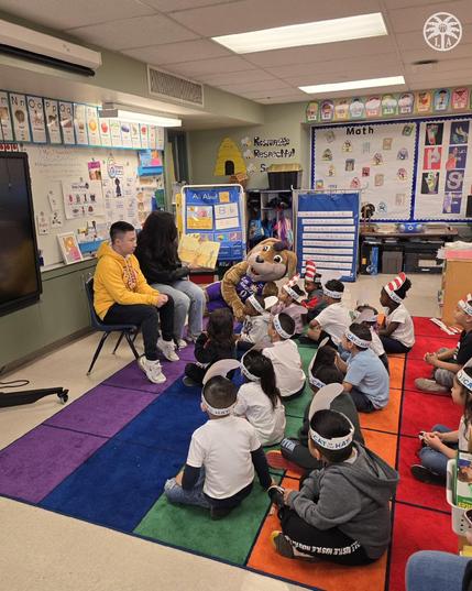 Sparks staff reads to pre-k children in honor of Read Across America Day while Sparky watches.