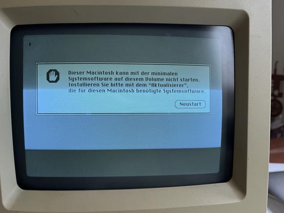 Vintage computer monitor displaying a German language error message indicating that the system software cannot be started and prompting for an update.