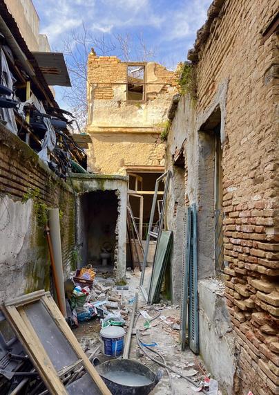A narrow lane between a crumbling brick wall on the left and a part-ruined house wall - also brick - on the right. It would have led to a courtyard behind the house. Now it’s full of rubble and construction paraphernalia- it’s being renovated, I talked to the builders.
In the back, the remains of an outhouse and behind it, another ruined brick building catching the sunlight.