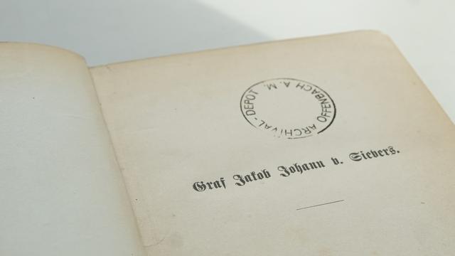 Aufgeschlagene Buchseite mit Schriftzug: Graf Jakob Johann von Sievers. Dazu Stempel mit Schriftzug: Archival-Depot Offenbach a. M.
