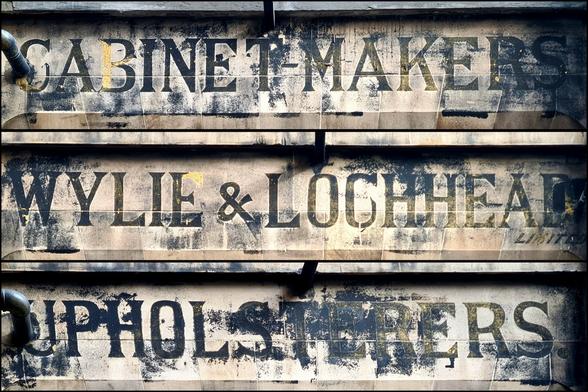 A ghost sign saying Cabinet-makers, Wylie and Lockhead Limited, Upholsterers.