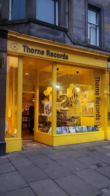 Bright yellow front of Thorne Records at dusk
