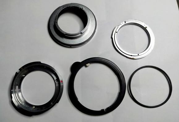 The parts making up the adapter:
Topcon re mount with 3 setscrews, the intermediary spacer to get flange distance right, the Uv topcor bayonet mount and the aperture ring. Also an o-ring, probably not original.