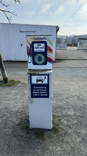 An electric vehicle charging station at Königstuhl in Rügen with signage indicating a fee of 1 euro per hour for use.