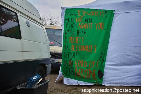 Banner an einem Pavillion: "Dear Tesla workers! We're not here to fight against you. We're here to protect our ressources and to fight for a good life for everyone."