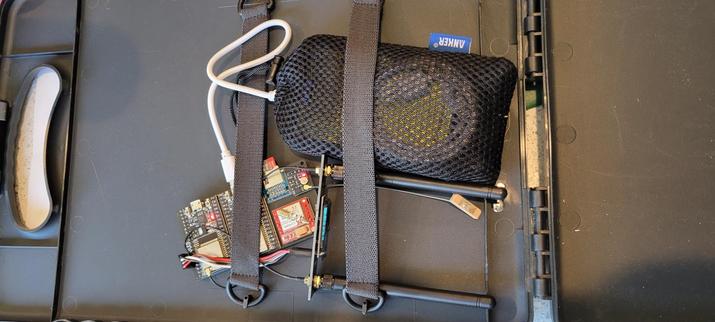 A Hackerboxes wifi "wispy" kit clipped into the inside of a clipboard attached to a large capacity USB battery