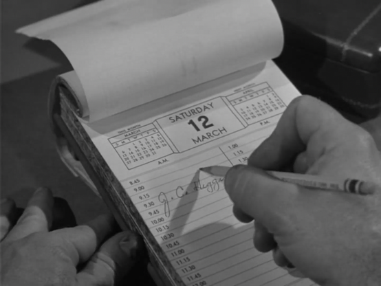 A man writing a name in the 9:30 a.m. time slot of the calendar page for Saturday March 21.