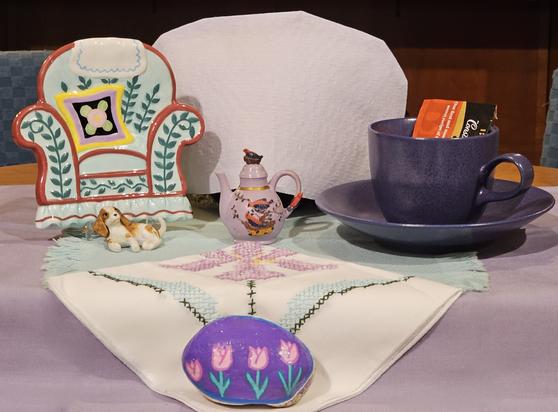 A tea tableau of a comfy, cozy scene complete with an armchair & a spaniel. The tea is Constant Comment black tea from Bigelow.