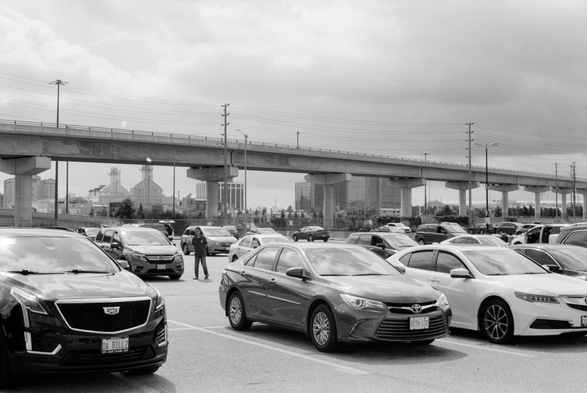 A concrete overpass crosses a large parking lot.