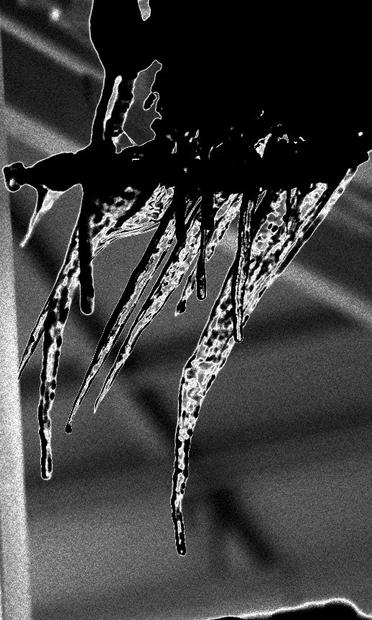 Hanging icicles bent on an angle creates a spiked abstract shape. The Monochrome photo has had a solarization effect, to turn the ice into a dramatic black.