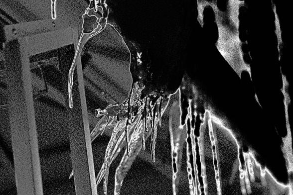 A medium shot of the same icicles shows more of the group, and provides a sense of surroundings, by revealing the braced metal of the overhang.
