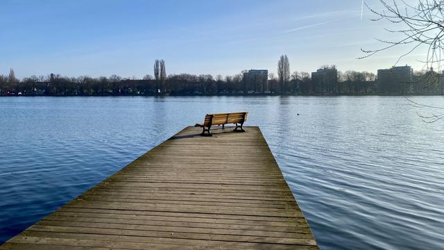 A small pier with a bench on it.