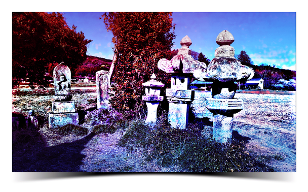 A row of stone lanterns near the edge of a field. A colorful filter has been added.
