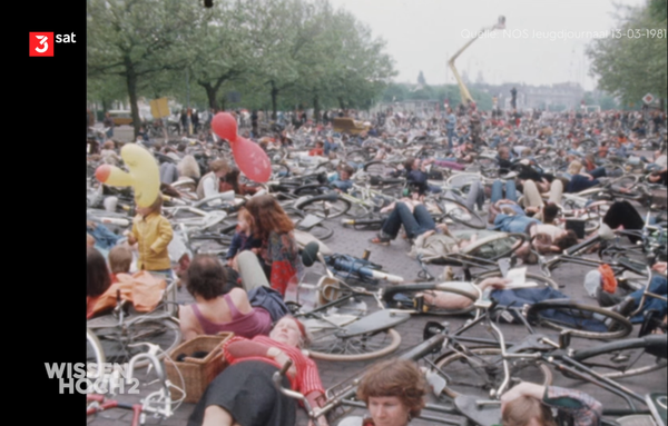 70er Jahre, große Straße, viele Fahrräder und Menschen liegen auf der Straße