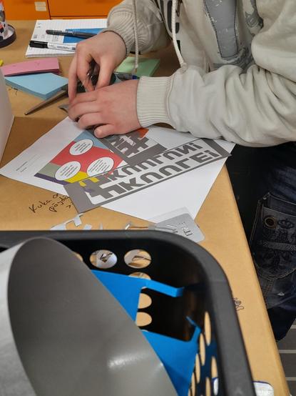 Preparing the vynil prints for pressing them on the cotton bags