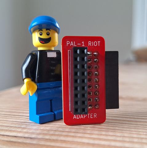 A LEGO reverend holding a tiny PCB
