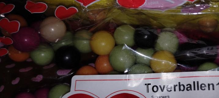 gekleurde snoepballetjes in een plastic zak met als opschrift 'toverballen'