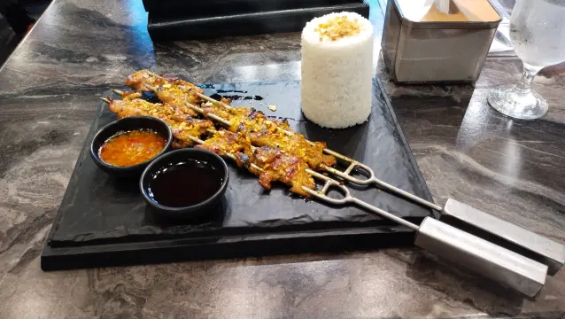 Double inasal boneless chicken thighs on skewers, with a cup of rice, and sides inasal sauce (chicken oil), and sugarcane vinegar