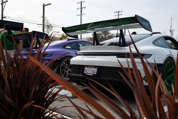 Rear view of a white sports coupe and a purple sports coupe.
