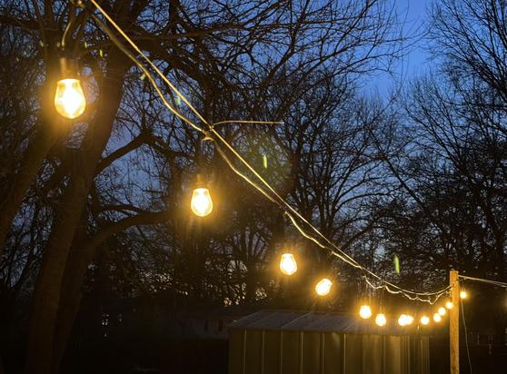 String lights give off a warm glow against a post-sunset dark blue sky.