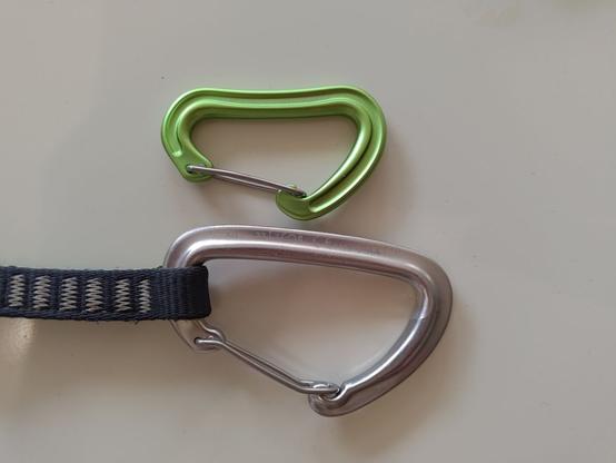 Two carabiners next to each other. One looks really tiny compared to the other.