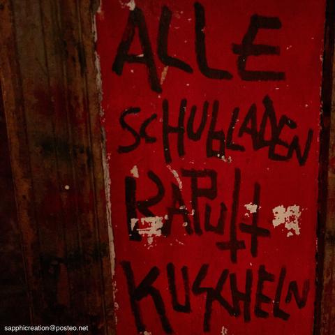 Schrift an einer roten Wand: "Alle Schubladen kaputt kuscheln".