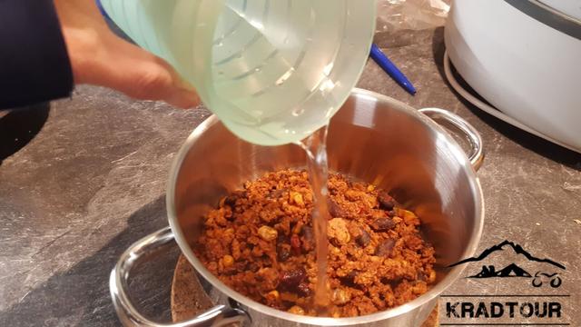 Chili con Carne wird mit kochendem Wasser vermengt.