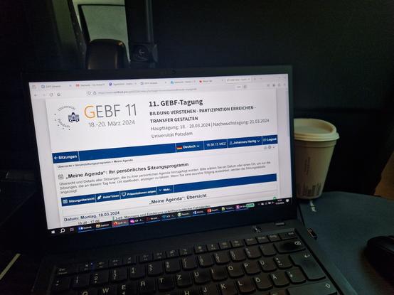 Notebook auf einem Klapptisch im ICE mit dem Programm der GEBF-Tagung im Browser.