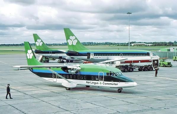 prop plane taxis infront while two jetliners pause in the back getting re-fueled