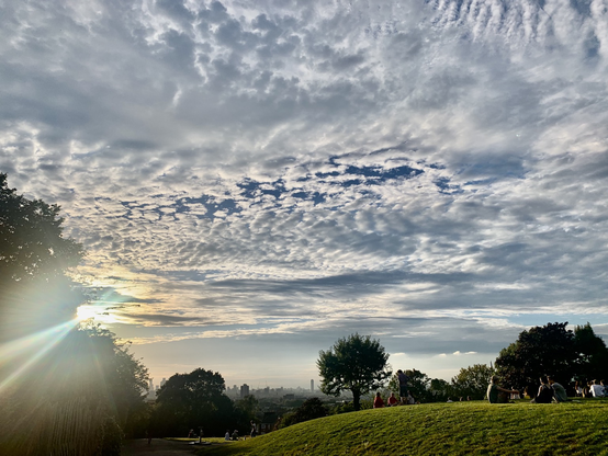 Mackerel sky view over a suburban hill with London in all its vastness beyond